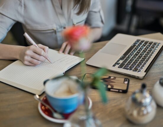 Photo by Judit Peter: https://www.pexels.com/photo/person-writing-on-a-notebook-beside-macbook-1766604/